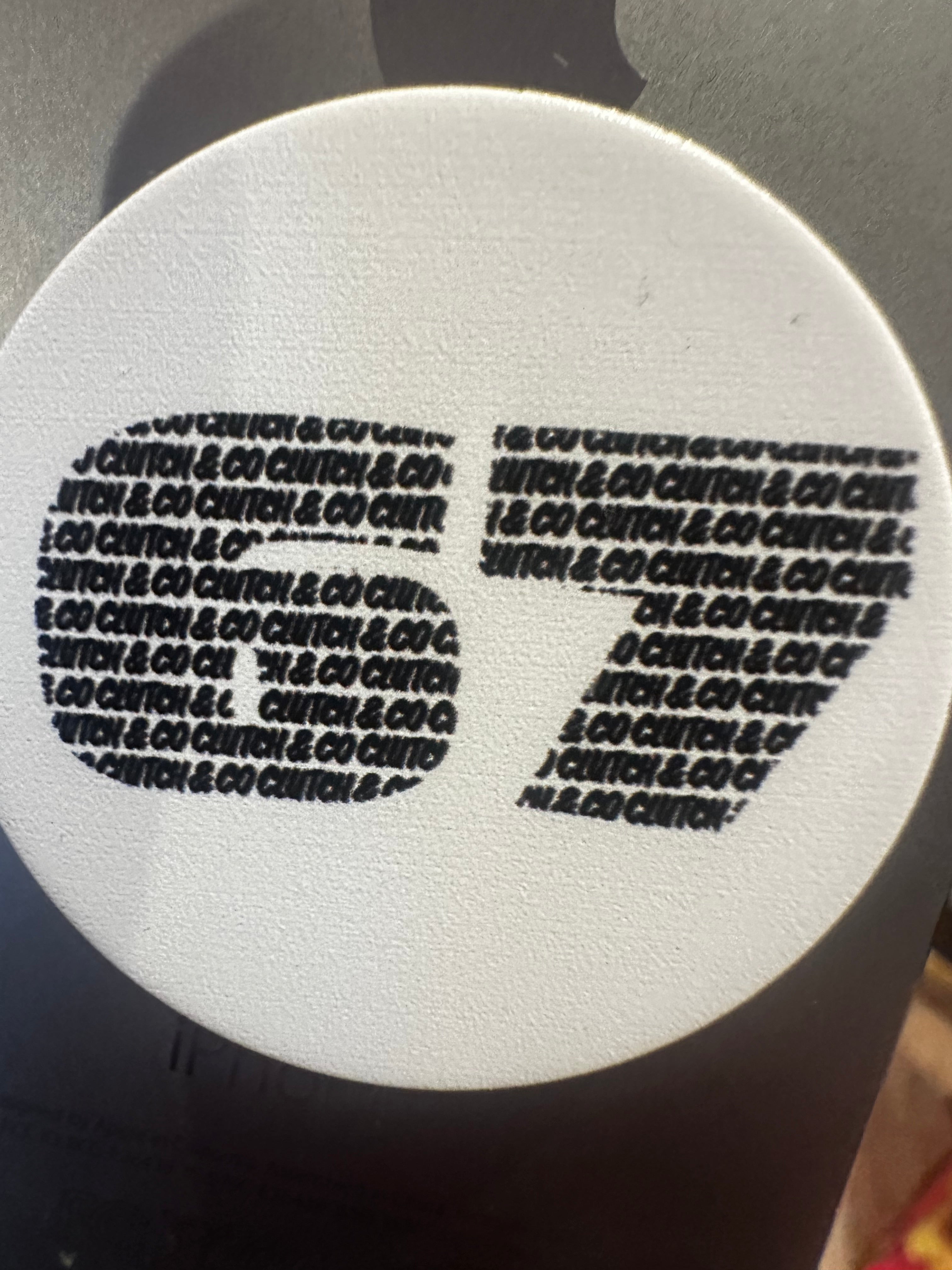 Circular white object with black text pattern on a gray background